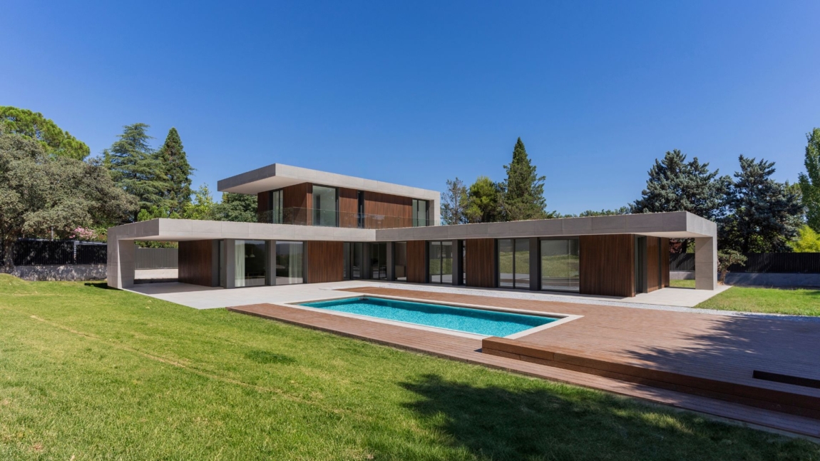 Fachada de casa en forma de L en Madrid con revestimiento de madera tecnológica