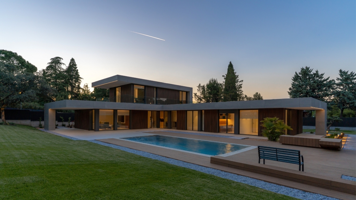 Fachada de casa en forma de L en Madrid con revestimiento de madera tecnológica