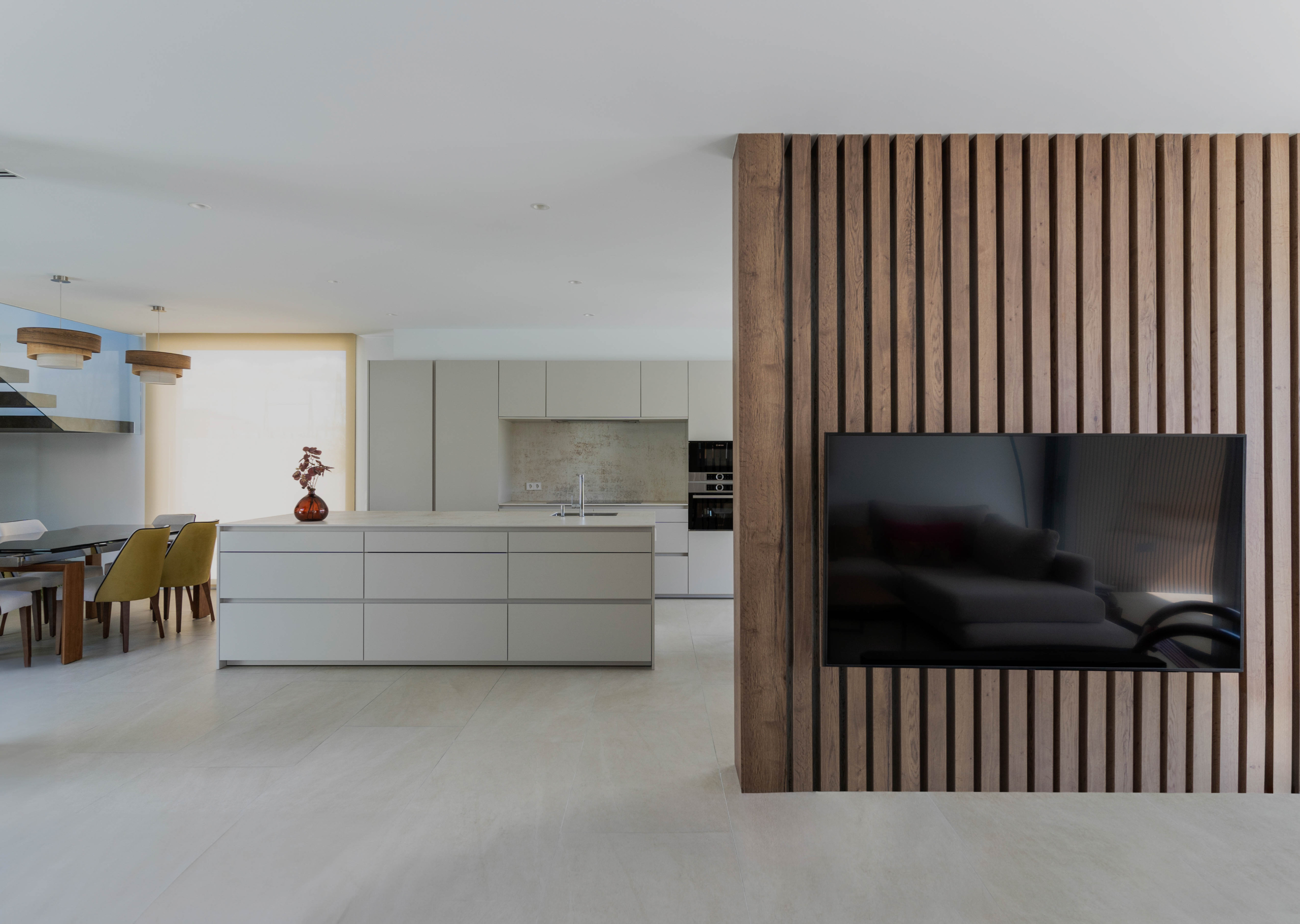Salón y cocina con muro divisor de madera tecnológica en casa prefabricada