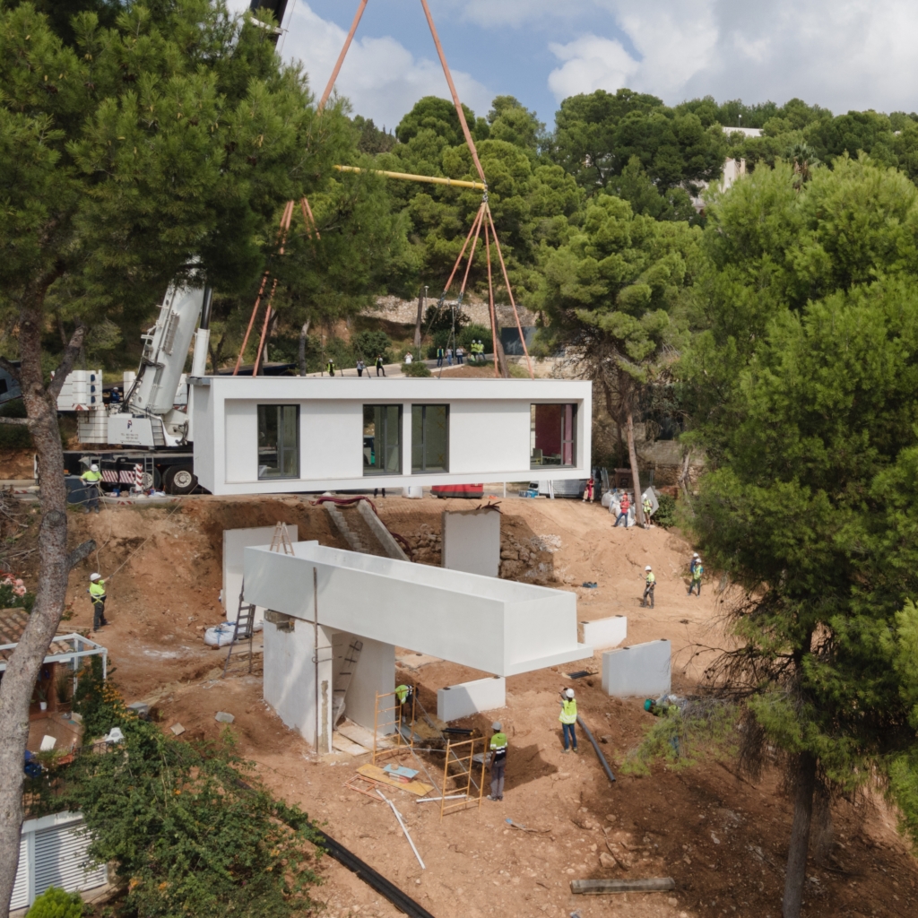 Vista aérea implantación de una casa modular y su voladizo en un bosque