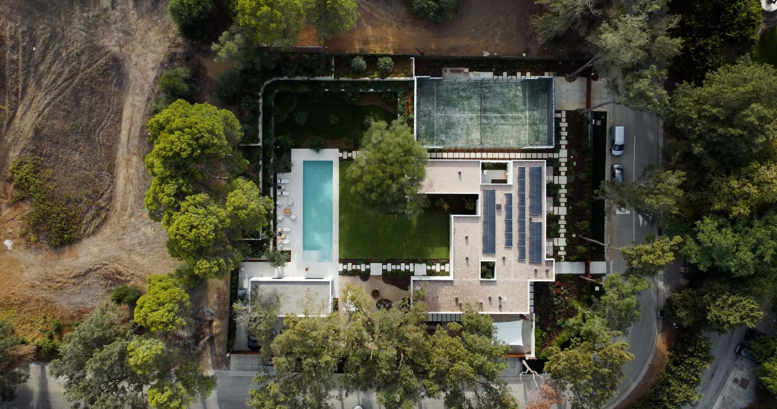 Construir para vender: Vista aérea terreno con instalaciones de pádel, jardín y piscina infinity