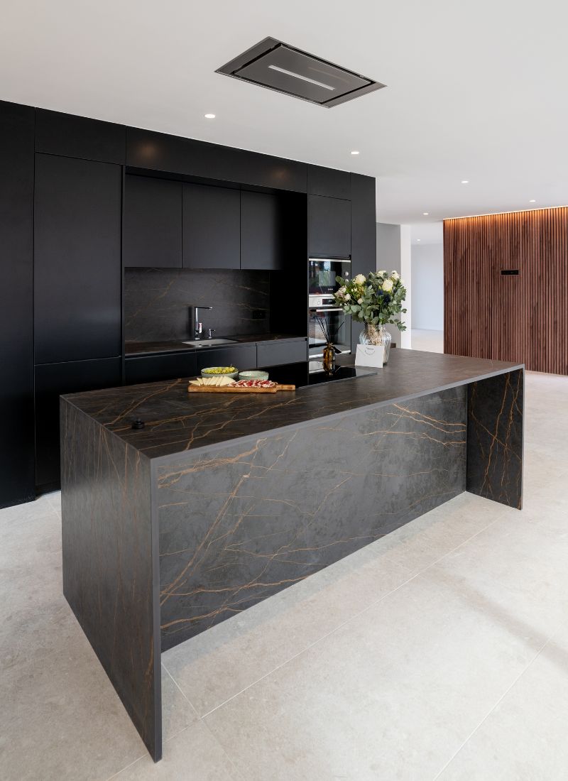 Kitchen in black tones and dark and golden island in modular house Alicante