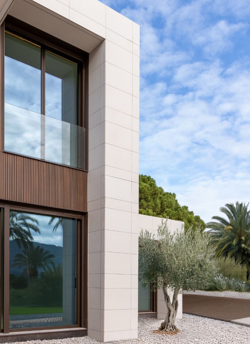 Facade of a modular house with wood and grey porcelain tiles in cantilevered form