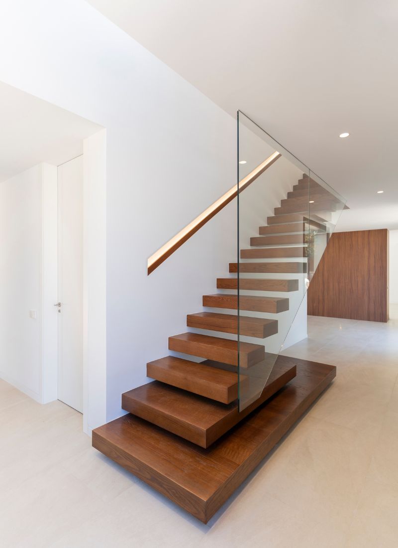 Escaleras de madera iluminadas con led y voladas en casa con forma de L en Madrid