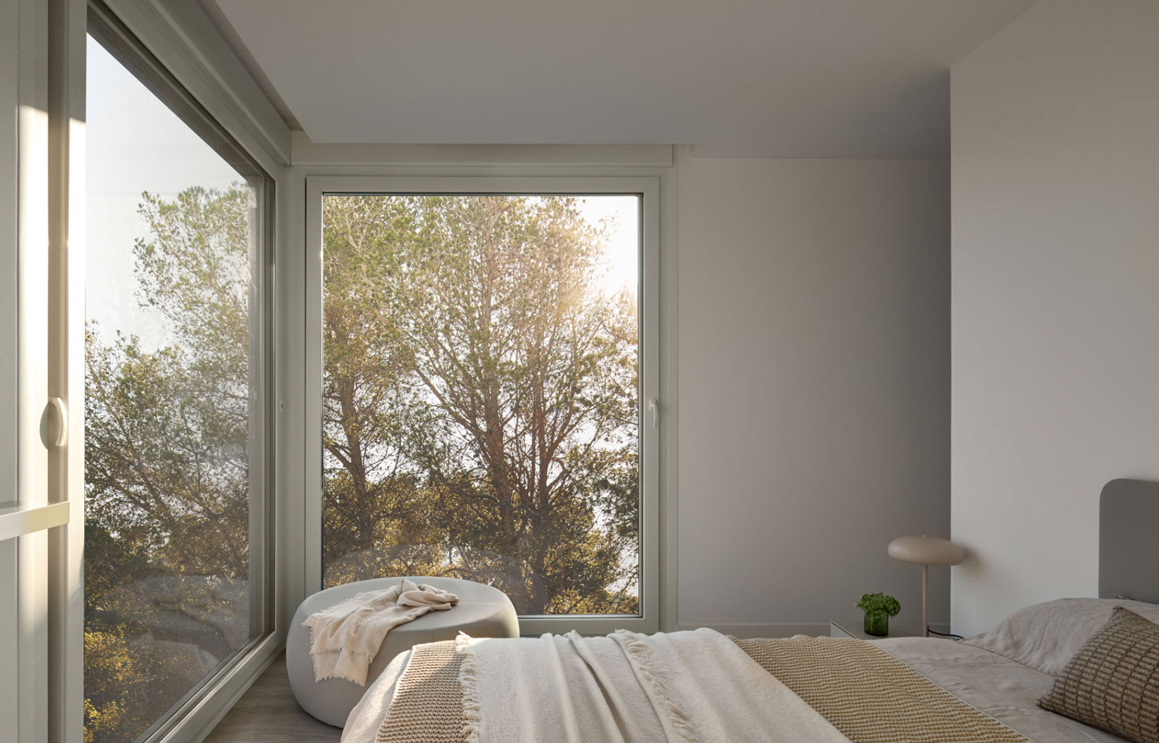 Dormitorio con rayos de luz proyectados, utilizando el estudio de soleamiento para mejorar la eficiencia térmica de una casa