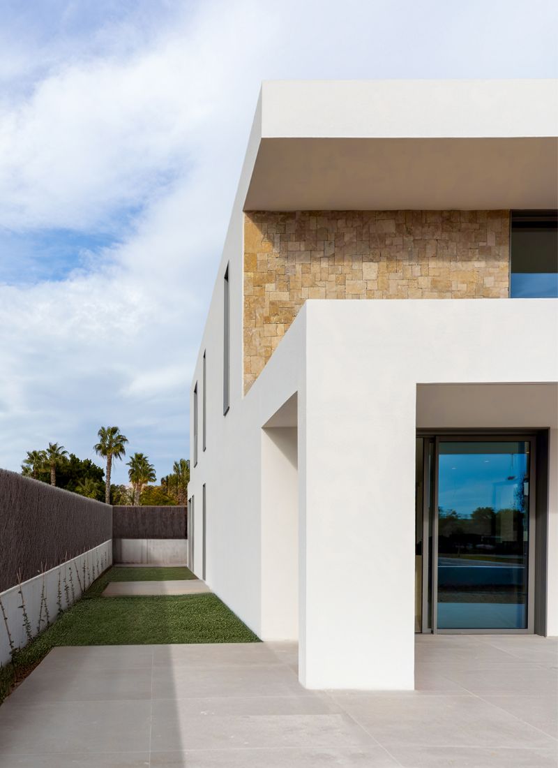 Fachada con piedra natural y monocapa blanco