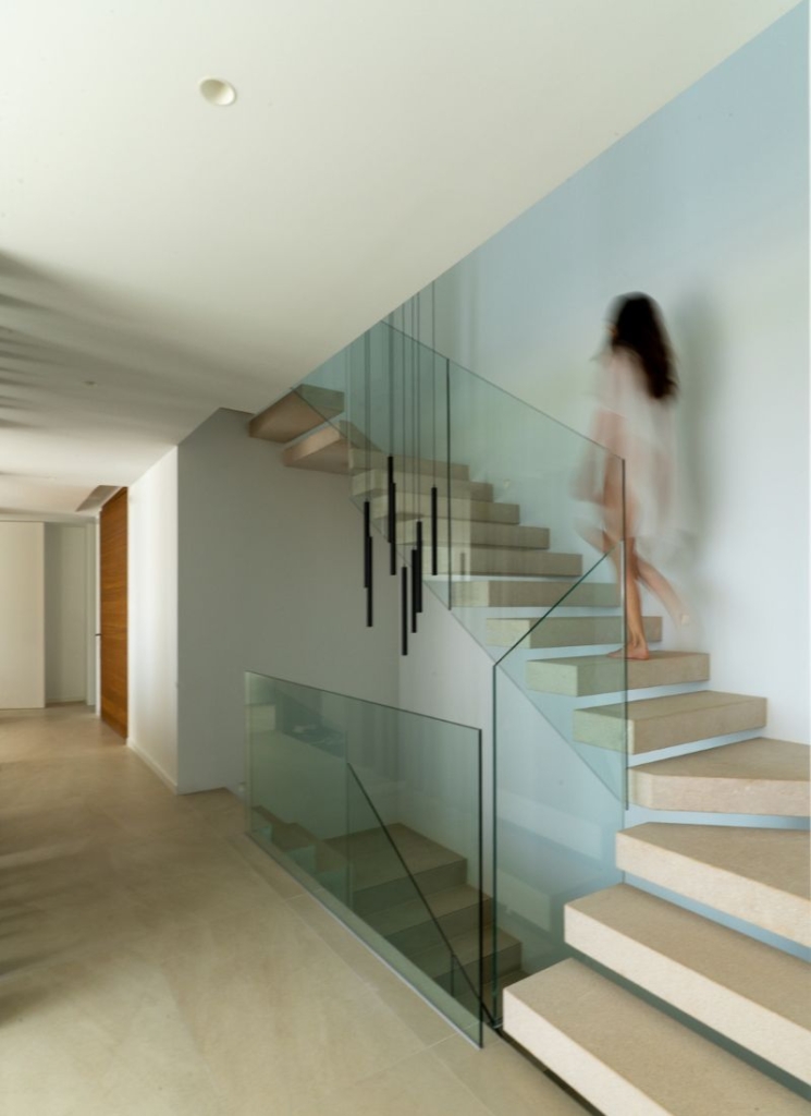 Escalera interior peldaños volados barandilla vidrio